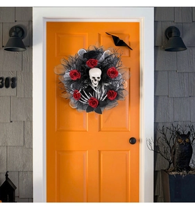 Detail of Halloween skull wreath with red roses and black mesh on an orange door
