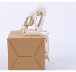 Détail de figurine de crâne en résine avec articulations métalliques en pose de penseur