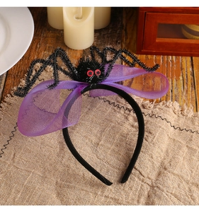 Détail du serre-tête d'Halloween avec araignée en peluche, yeux rouges et nœud en tulle violet
