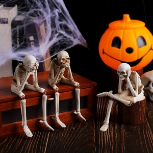 Halloween skeleton resin figurines with hanging legs in a spooky pumpkin scene setup