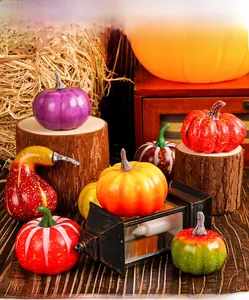 Assorted colorful artificial pumpkins and gourds on rustic wood for harvest decor