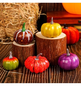 Assorted artificial pumpkins in various colors and textures displayed on wooden stumps