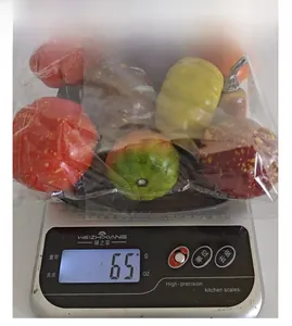 Detailed view of colorful foam pumpkins on a scale showing a total weight of 65g