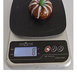 Close-up of lightweight foam pumpkin decoration showing realistic texture on weighing scale