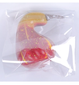 Macro detail of artificial pear-shaped pumpkin with golden-to-red gradient and dots