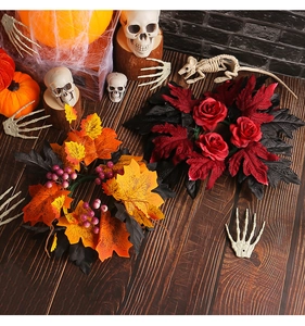 Detail of Halloween candle rings with red roses, maple leaves and gothic decor on dark wood