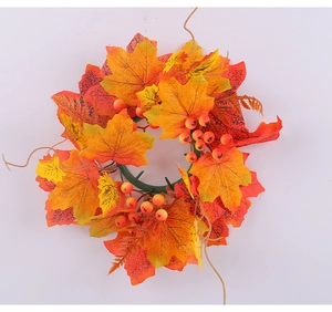 Detail of autumn candle ring with realistic maple leaves and bright orange berries