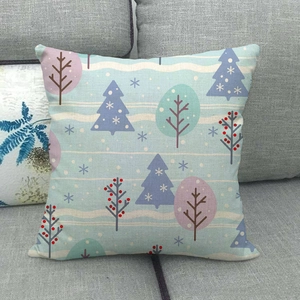 Detail of linen Christmas pillowcase with Nordic winter trees on a gray sofa