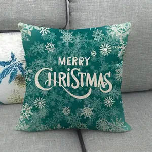 Green Christmas linen pillow cover with white snowflakes and Merry Christmas text on sofa
