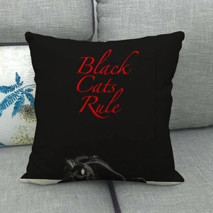 Linen pillowcase with Black Cats Rule print on grey sofa in a cozy home setting