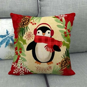 Dettaglio federa in lino natalizia con pinguino e sciarpa rossa su divano in tessuto