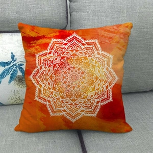 Close-up of orange gradient linen pillowcase with white mandala lace pattern on a sofa