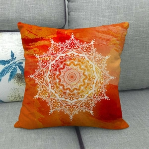 Orange linen throw pillow cover with white mandala pattern on a grey sofa