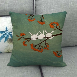 Close-up of cute cartoon rabbits on autumn linen pillow cover over grey sofa texture