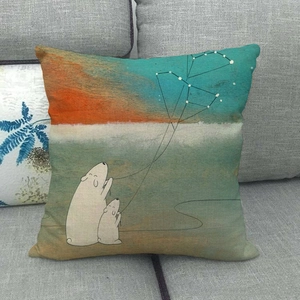 Detail of linen cushion cover showing white bears illustration on a grey fabric sofa