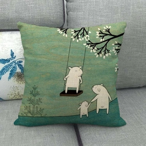 Close-up of linen cushion cover showing white bears illustration on a grey sofa