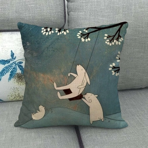 Linen pillow cover with cartoon bunnies under a flowering tree on a gray sofa