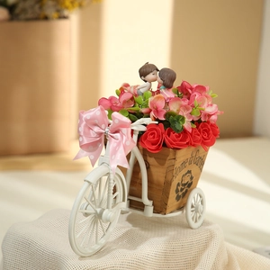Close-up of romantic mini bicycle decor with artificial roses and kissing couple figurines