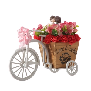 Romantic rose flower arrangement in tricycle cart with cute kissing couple dolls for decor