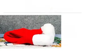 Close-up of the red velvet fabric and white plush trim of the classic Christmas hat