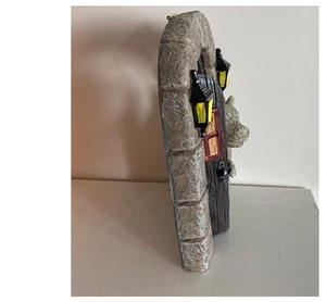 Dettaglio di statuetta a forma di drago che sbuca da un arco in finto marmo