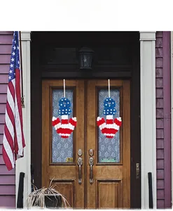 Patriotic anchor wreaths with red white and blue artificial flowers on wooden front doors