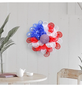 Detail of red white and blue July 4th deco mesh wreath with stars hanging on a wall