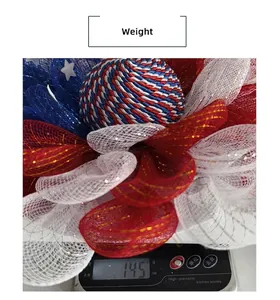 Red white and blue July 4th wreath being weighed on a scale showing 145g weight