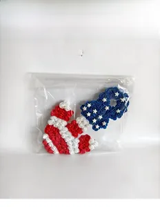 Detail of red white and blue foam rose wreath packaged in a clear protective plastic bag