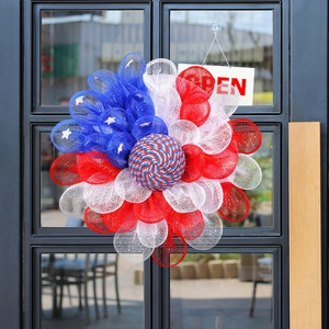 Patriotic 4th of July wreath with red white and blue mesh on a glass front door