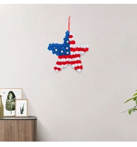 Close-up of patriotic American flag wreath with red white blue roses on a gray wall