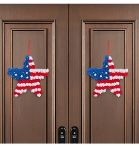 Detail of red white and blue star-shaped patriotic wreaths hanging on dark wooden doors