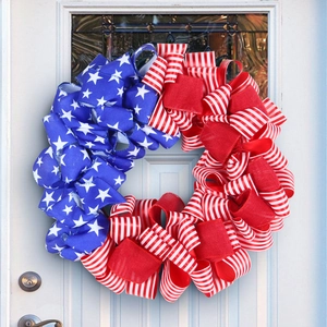 Independence Day wreath with red white blue ribbons on a white front door decor