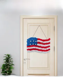 Detail of American flag themed faux rose wreath hanging on a white wooden door decor