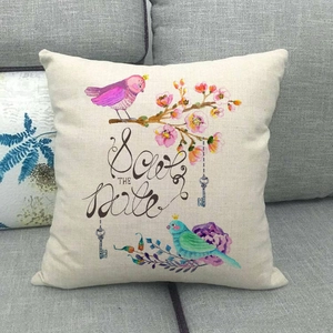 Close-up of linen cushion cover featuring hand-painted birds and cherry blossoms print