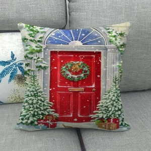 Detail view of linen Christmas pillowcase featuring a red door and wreath on a gray sofa