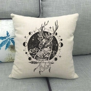 Federa quadrata in lino con design astrologico di renna nera posata su un divano