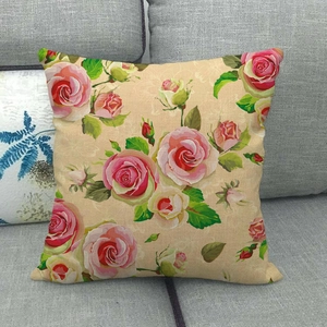 Close-up of square linen pillowcase with vintage rose floral print on a grey sofa