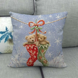 Detail of Christmas linen cushion cover featuring teddy bears in stockings on a blue background