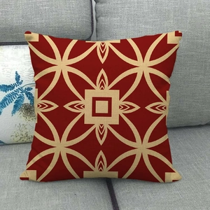 Vierkante linnen kussenhoes met rood geometrisch patroon op grijze stoffen bank