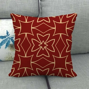 Linnen kussenhoes met rood geometrisch bloemenpatroon op een grijze bank