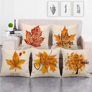 Detailed set of 5 autumn-themed linen pillowcases with maple leaves on sofa