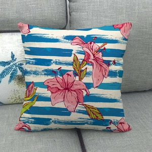 Linen cushion cover featuring dark blue stripes and vibrant pink lilies on a gray sofa