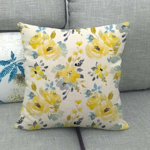 Detailed texture of linen throw pillow case featuring yellow and grey floral patterns