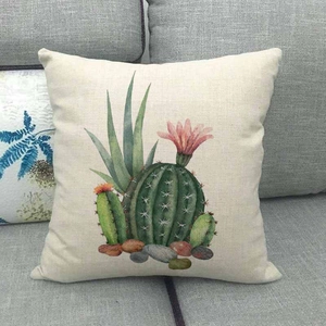 Vue détaillée d'une housse de coussin en lin avec motif cactus aquarelle sur canapé gris