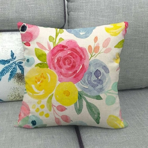 Linen cushion cover with watercolor floral pattern on a grey sofa for home decor