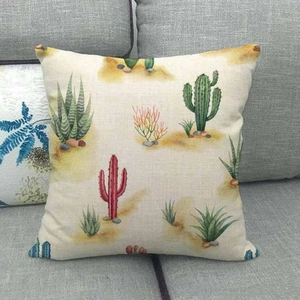 Détail de la housse de coussin en lin avec imprimé cactus sur un canapé gris déco
