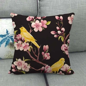 Detail of linen cushion cover with plum blossom and bird print on grey sofa background