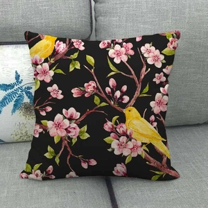 Detailed texture of linen cushion cover with plum blossom and yellow bird on gray sofa