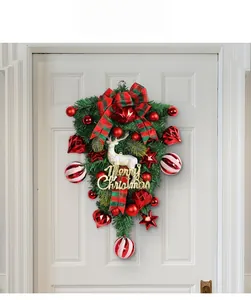 Detail of Christmas teardrop wreath with white reindeer and plaid bow on door